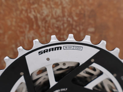 Kassette & Zahnkränze von Sram, SRAM FORCE XG 1270 E1 KASSETTE ZAHNKRANZ 10-33 ZÄHNE vor USEDBIKES-OB.DE Hintergrund