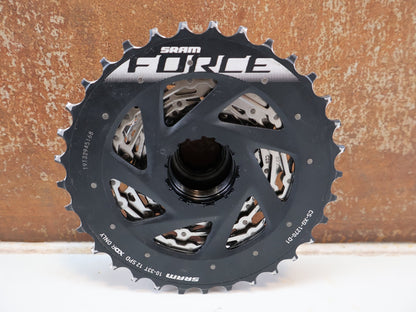 Kassette & Zahnkränze von Sram, SRAM FORCE XG-1270 KASSETTE / 12-FACH RENNRAD / 10-33 ZÄHNE X-RANGE DRIVER vor USEDBIKES-OB.DE Hintergrund