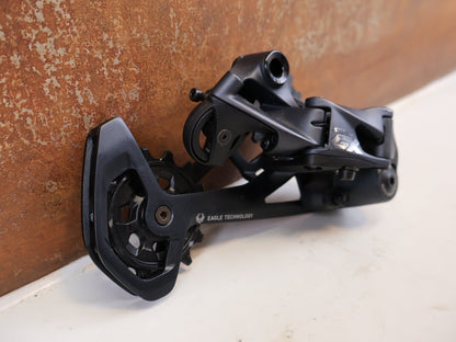 Schaltungsteile von Sram, SRAM GX EAGLE SCHALTWERK 12-FACH TYPE 3.0 LUNAR GRAU 52T vor USEDBIKES-OB.DE Hintergrund