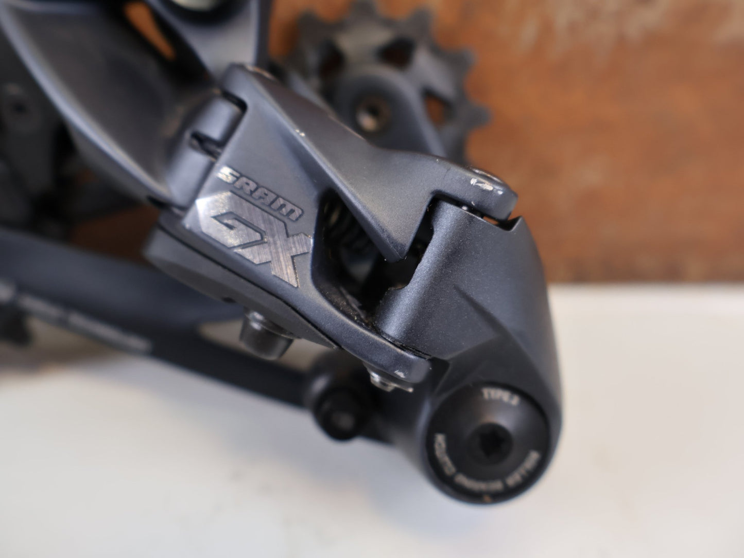 Schaltungsteile von Sram, SRAM GX EAGLE SCHALTWERK 12-FACH TYPE 3.0 LUNAR GRAU 52T vor USEDBIKES-OB.DE Hintergrund