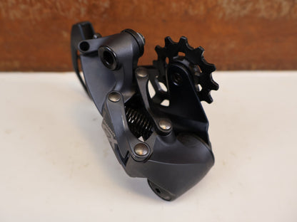 Schaltungsteile von Sram, SRAM GX EAGLE SCHALTWERK 12-FACH TYPE 3.0 LUNAR GRAU 52T vor USEDBIKES-OB.DE Hintergrund