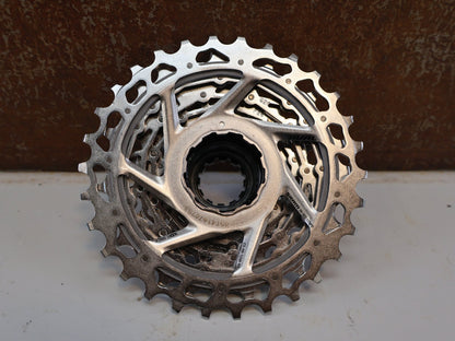Kassette & Zahnkränze von Sram, SRAM KASSETTE XG-1250 / 12-FACH ZAHNKRANZ / 10-30T / ROAD GRAVEL vor USEDBIKES-OB.DE Hintergrund