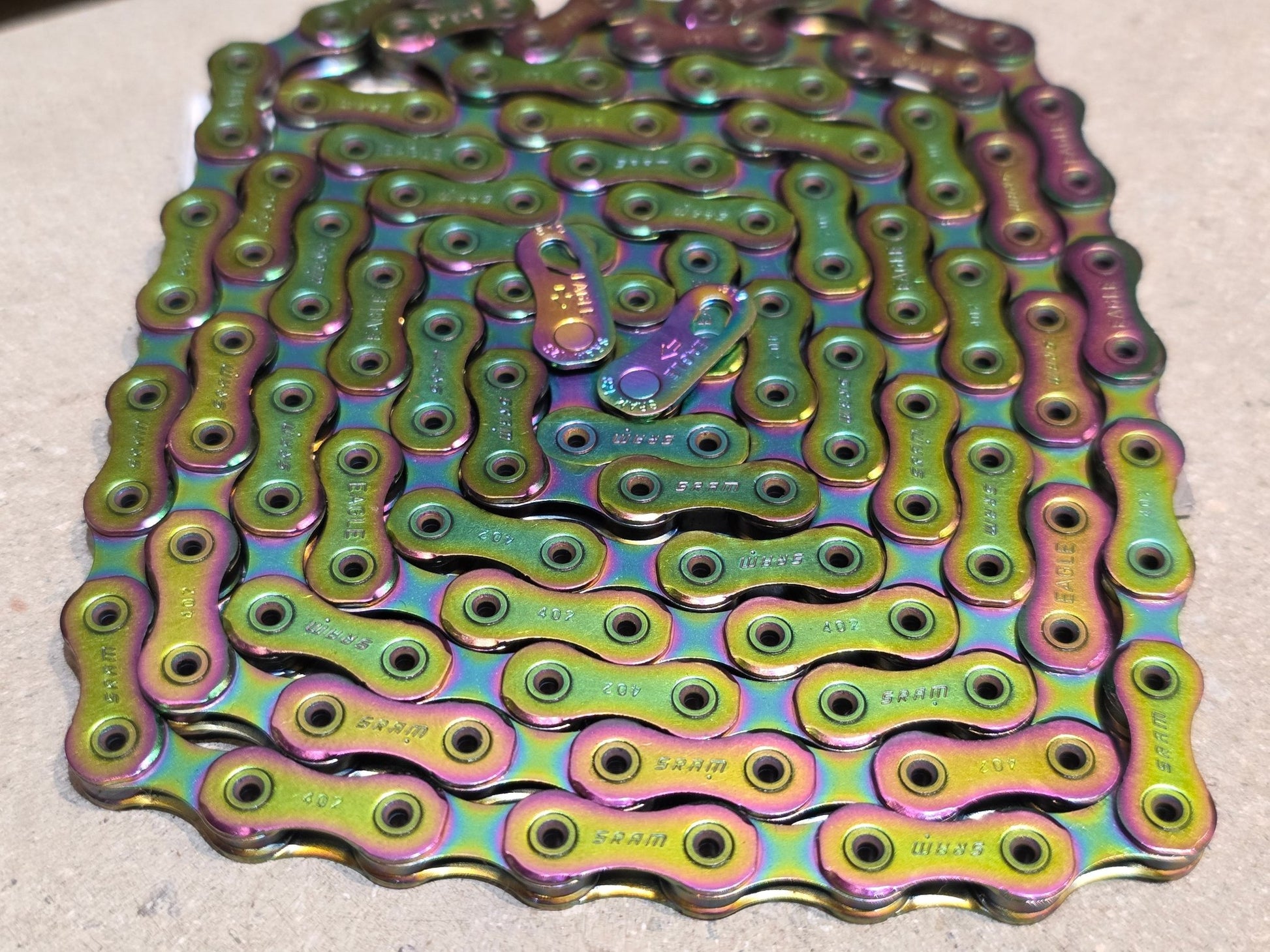 Zubehör von Sram, SRAM KETTE XX1 EAGLE HOLLOW PIN RAINBOW / 126 GLIEDER vor USEDBIKES - OB.DE Hintergrund