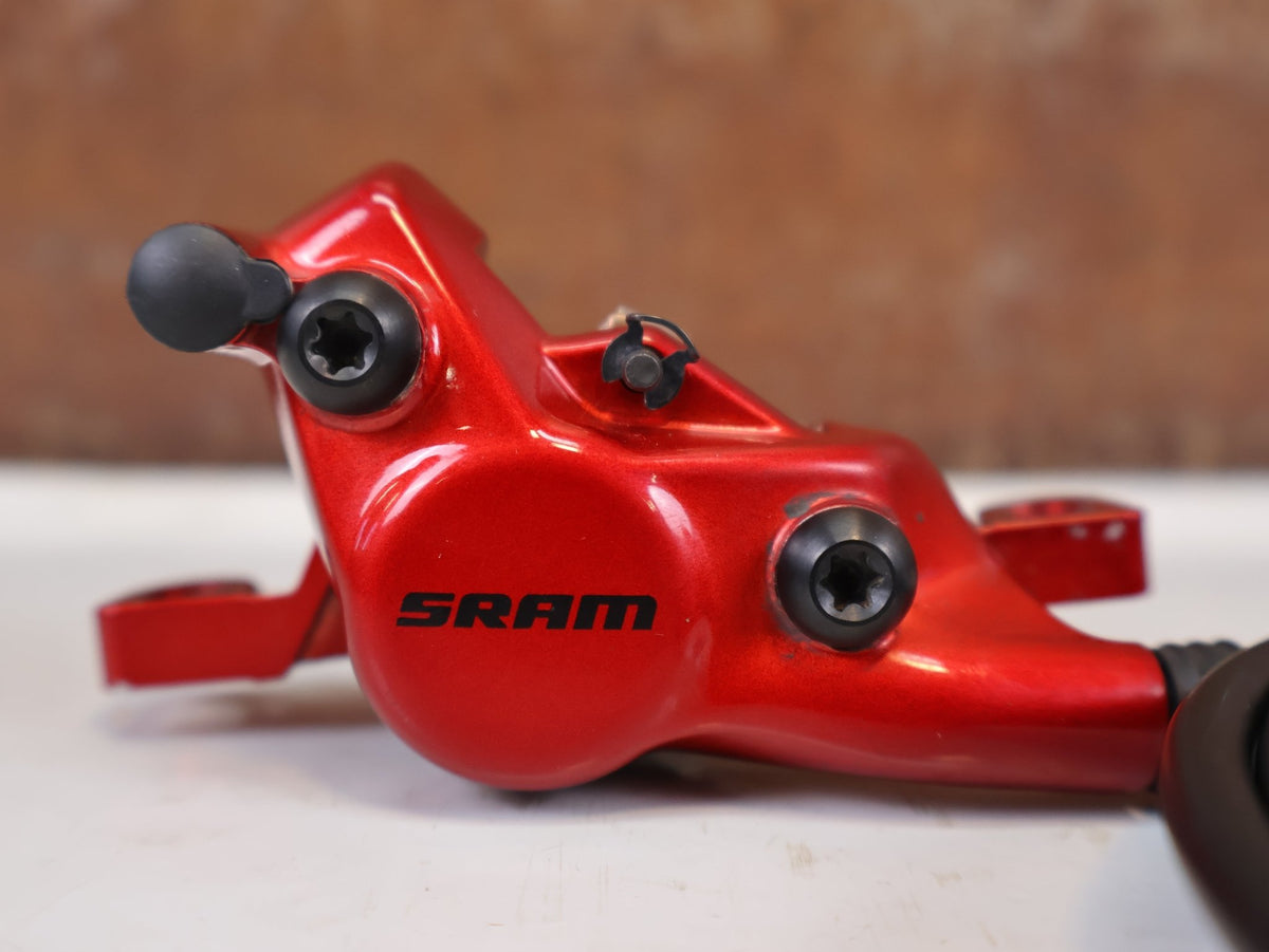 Bremse von Sram, SRAM Level Ultimate Bremsen Set Red Nino Schurter vor USEDBIKES-OB.DE Hintergrund