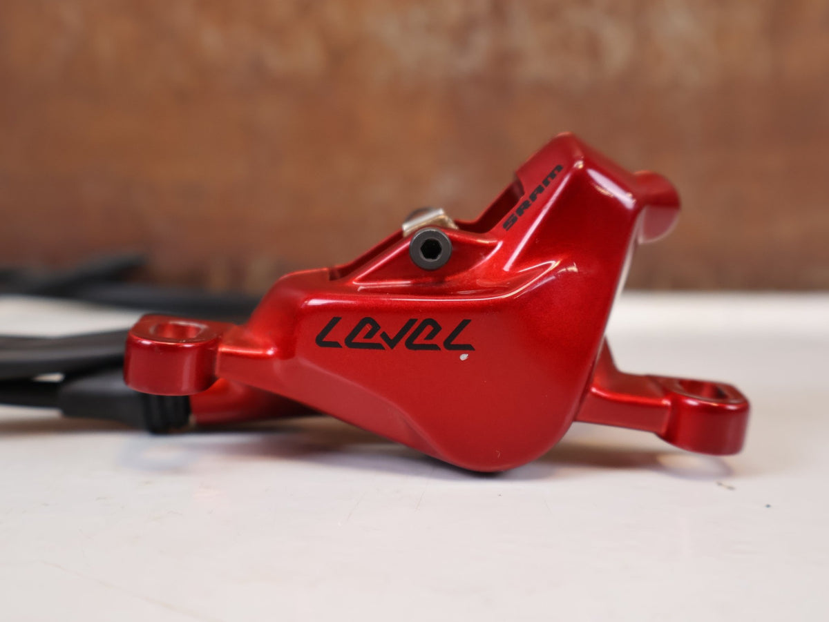 Bremse von Sram, SRAM Level Ultimate Bremsen Set Red Nino Schurter vor USEDBIKES-OB.DE Hintergrund