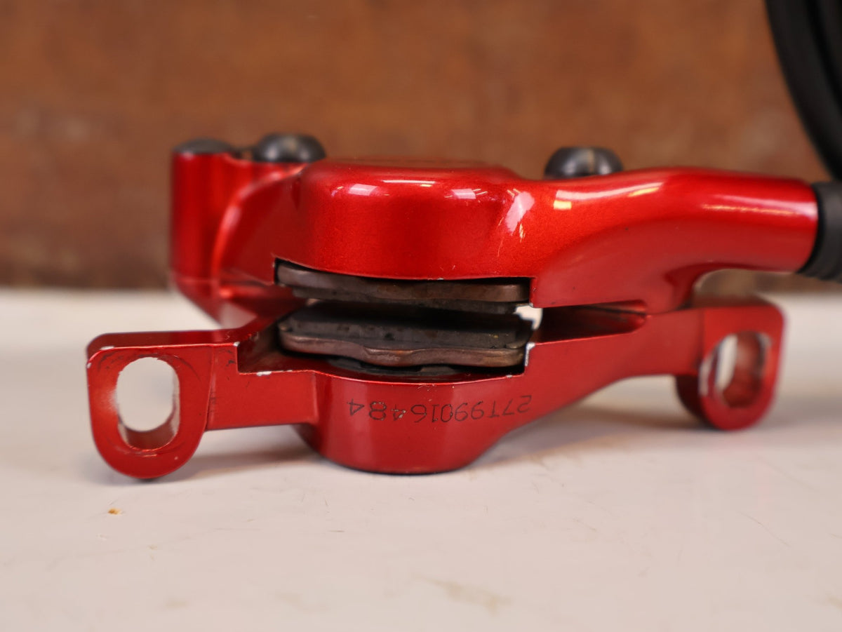 Bremse von Sram, SRAM Level Ultimate Bremsen Set Red Nino Schurter vor USEDBIKES-OB.DE Hintergrund