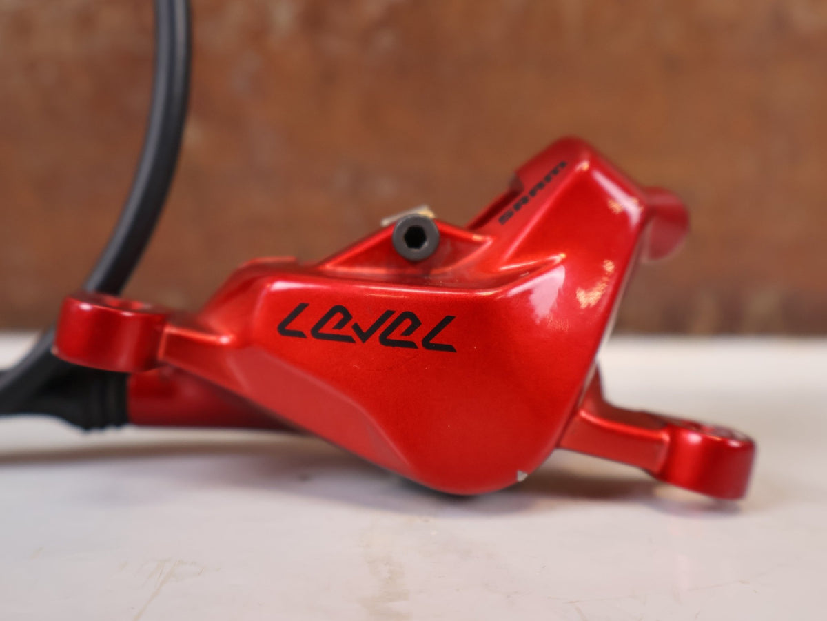 Bremse von Sram, SRAM Level Ultimate Bremsen Set Red Nino Schurter vor USEDBIKES-OB.DE Hintergrund