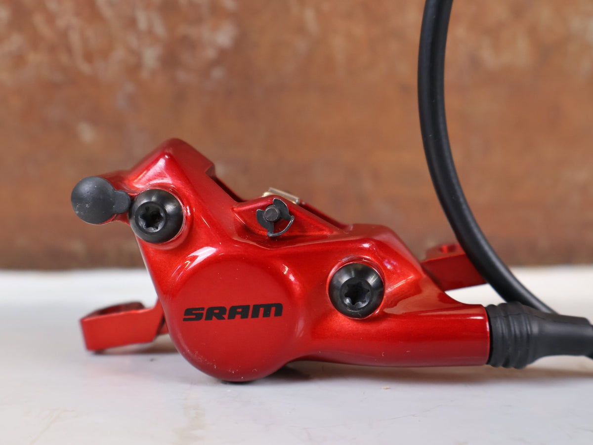 Bremse von Sram, SRAM Level Ultimate Bremsen Set Red Nino Schurter vor USEDBIKES-OB.DE Hintergrund