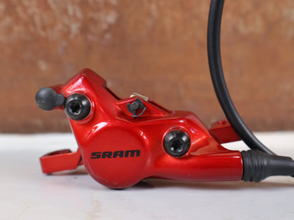 Bremse von Sram, SRAM Level Ultimate Bremsen Set Red Nino Schurter vor USEDBIKES-OB.DE Hintergrund