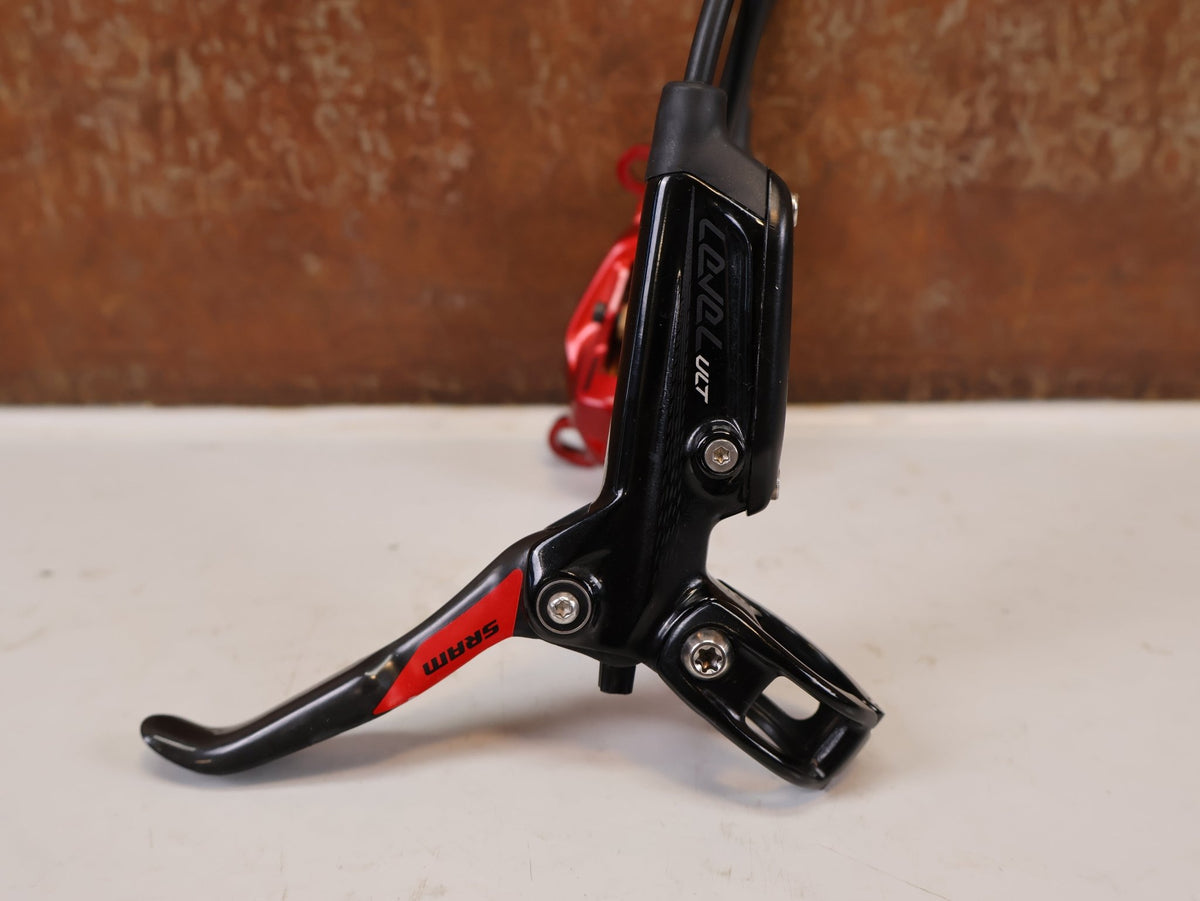 Bremse von Sram, SRAM Level Ultimate Bremsen Set Red Nino Schurter vor USEDBIKES-OB.DE Hintergrund