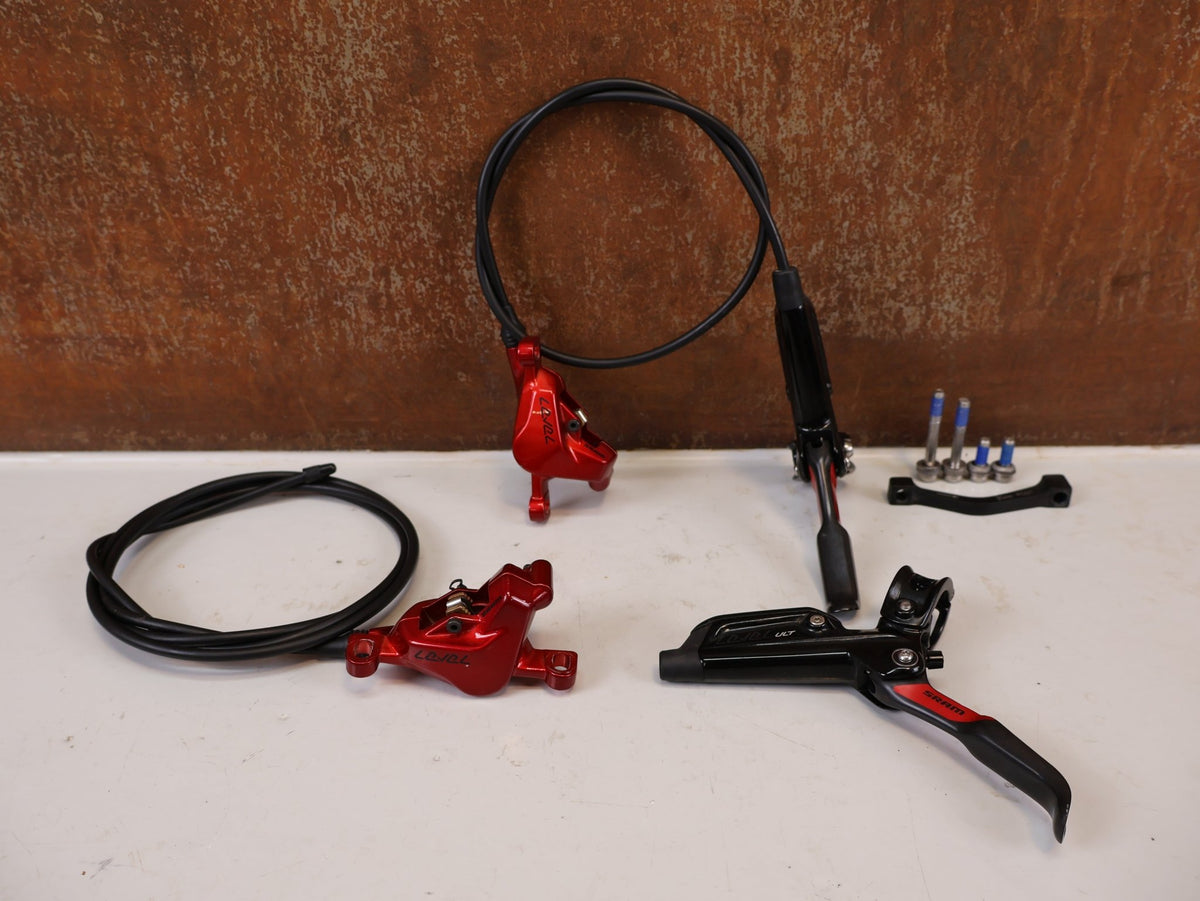 Bremse von Sram, SRAM Level Ultimate Bremsen Set Red Nino Schurter vor USEDBIKES-OB.DE Hintergrund