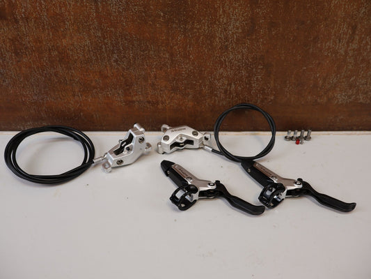 Bremse von Sram, SRAM MOTIVE ULTIMATE STEALTH V2 BREMSEN SET / 4-KOLBEN MINERALÖL CARBON XC TRAIL vor USEDBIKES-OB.DE Hintergrund