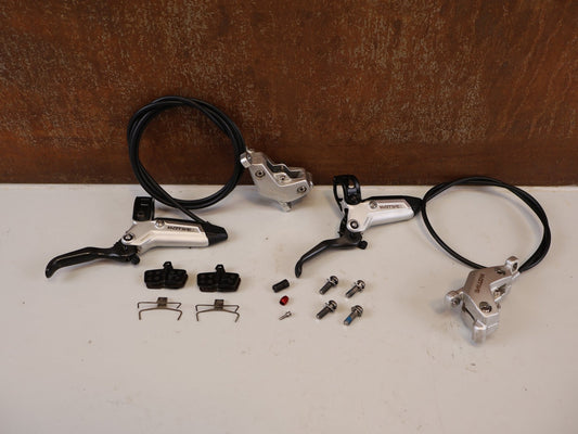 Bremse von Sram, SRAM MOTIVE ULTIMATE STEALTH V2 SCHEIBENBREMSE SET/ 4-KOLBEN vor USEDBIKES-OB.DE Hintergrund