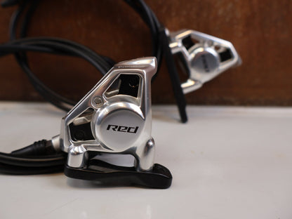 Brems-/ Schalthebel von Sram, SRAM RED AXS E1 Schalt Bremshebel Set Flatmount vor USEDBIKES-OB.DE Hintergrund