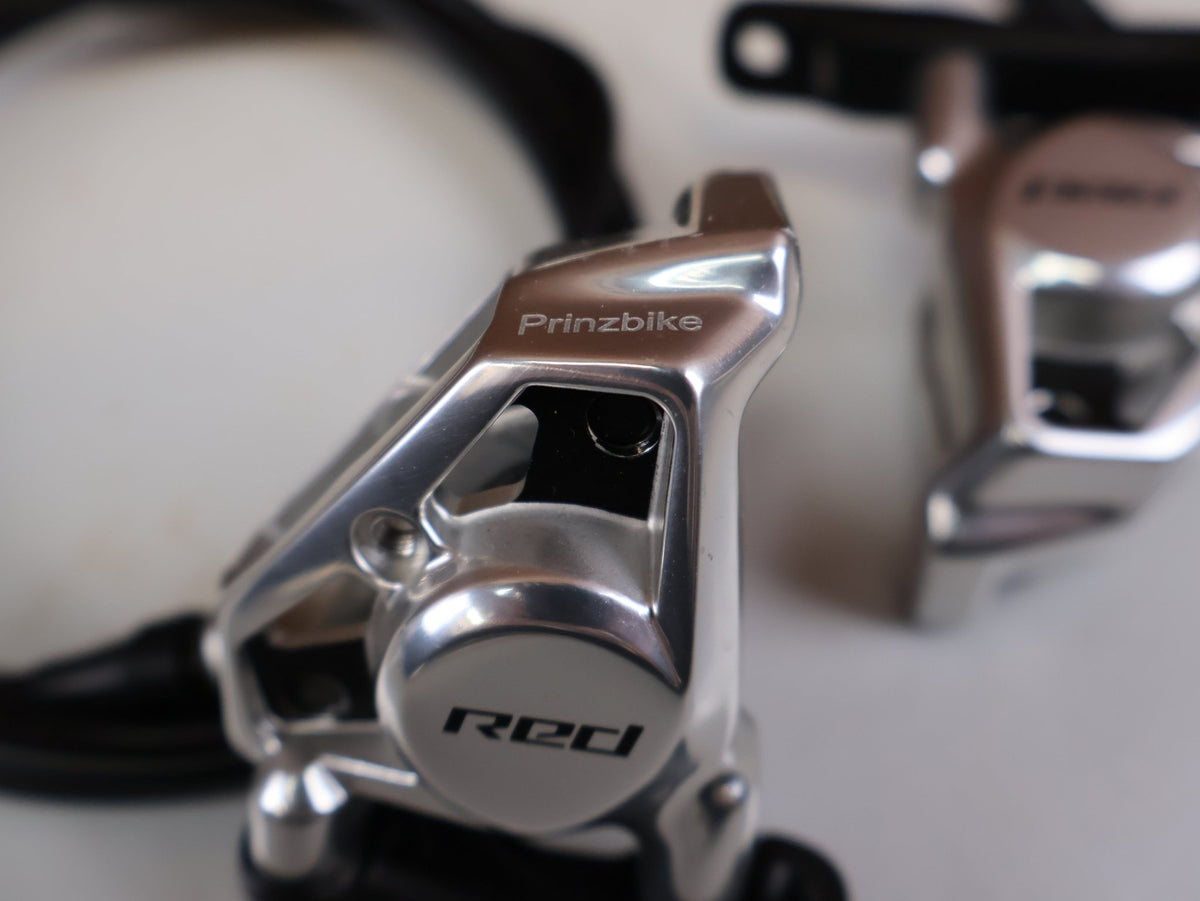 Brems-/ Schalthebel von Sram, SRAM RED AXS E1 Schalt Bremshebel Set Flatmount vor USEDBIKES-OB.DE Hintergrund
