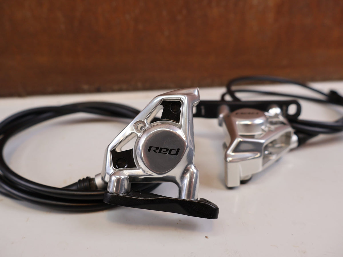 Brems-/ Schalthebel von Sram, SRAM RED AXS E1 Schalt Bremshebel Set Flatmount vor USEDBIKES-OB.DE Hintergrund