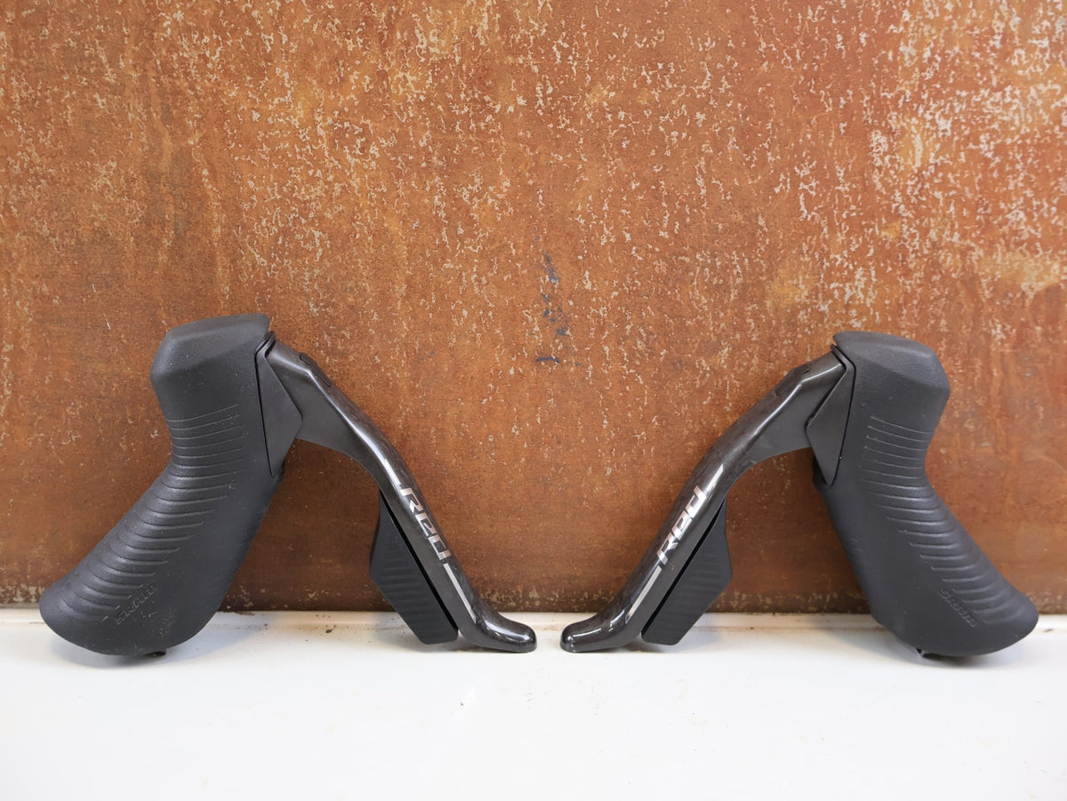 Brems-/ Schalthebel von Sram, SRAM RED AXS E1 Schalt Bremshebel Set Flatmount vor USEDBIKES-OB.DE Hintergrund