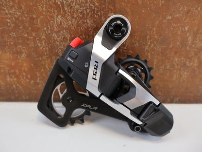 Schaltungsteile von Sram, SRAM RED E1 XPLR AXS SCHALTWERK / 1x13 - FACH / GRAVEL / UDH MOUNT vor USEDBIKES - OB.DE Hintergrund