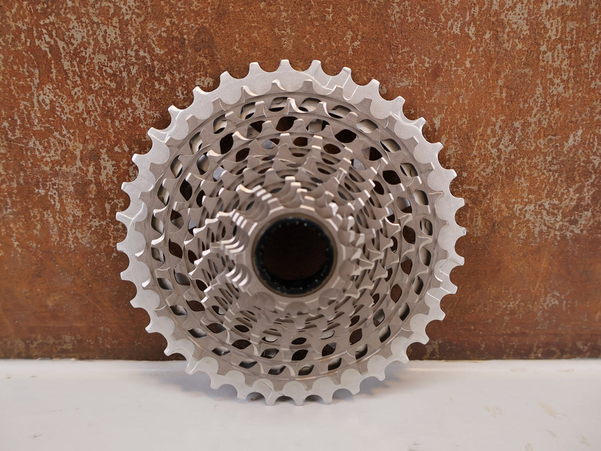 Kurbel von Sram, SRAM RED XG-1290 E1 12-fach Kassette 10-36T X-Dome Silver vor USEDBIKES-OB.DE Hintergrund
