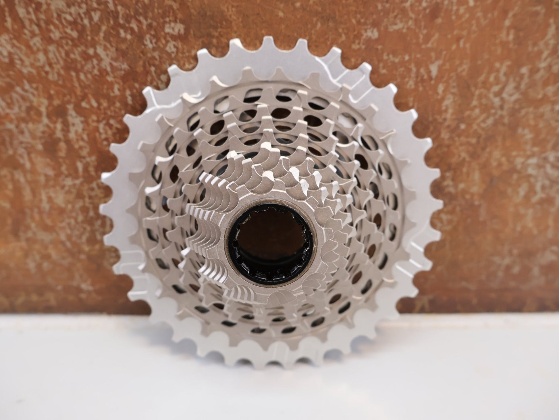 Kurbel von Sram, SRAM RED XG - 1290 E1 KASSETTE / 12 - FACH / 10 - 33T / XDR / SILBER / 206G vor USEDBIKES - OB.DE Hintergrund