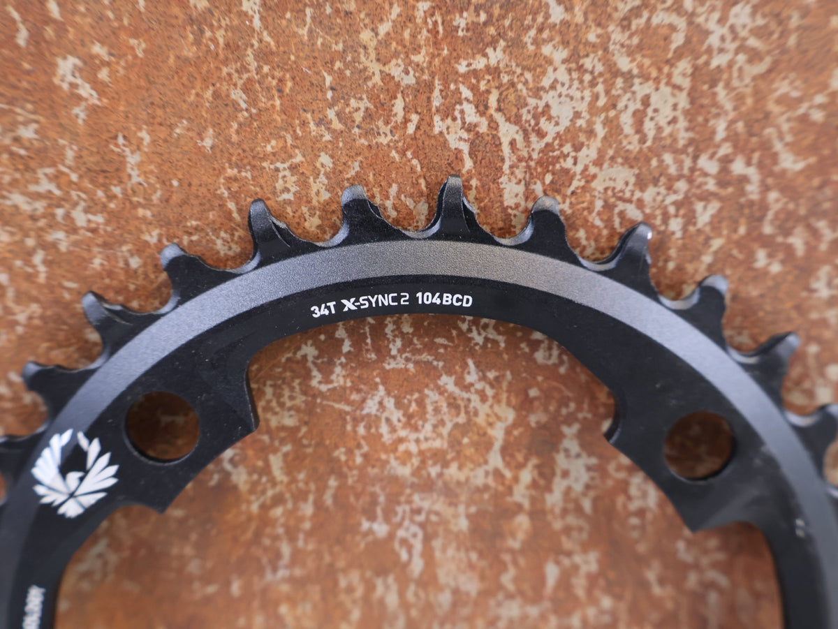 Kettenblatt von Sram, SRAM X-SYNC 2 EAGLE KETTENBLATT 34T 104 MM BCD vor USEDBIKES-OB.DE Hintergrund