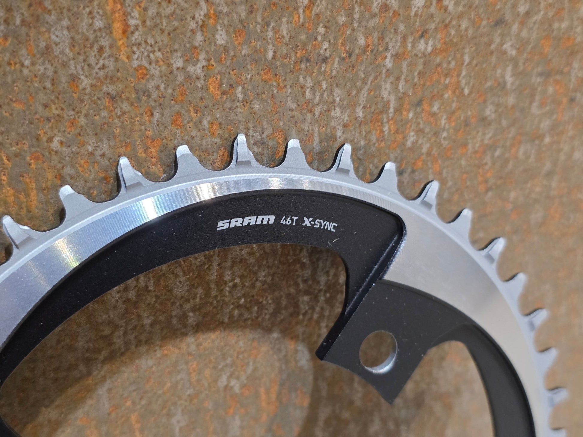 Kettenblatt von Sram, SRAM X - SYNC AXS KETTENBLATT ROAD BCD 107 MM / 46 ZÄHNE vor USEDBIKES - OB.DE Hintergrund