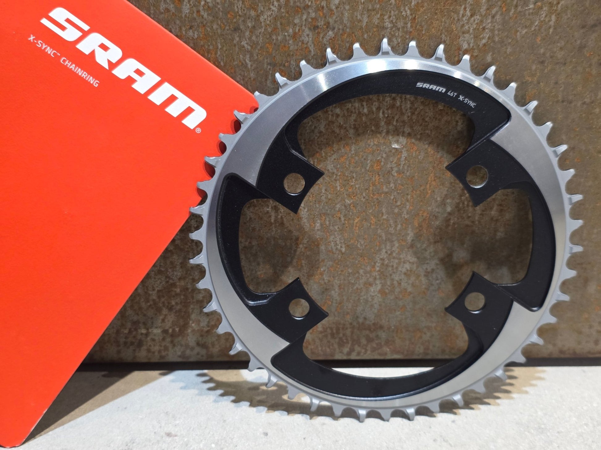 Kettenblatt von Sram, SRAM X - SYNC AXS KETTENBLATT ROAD BCD 107 MM / 46 ZÄHNE vor USEDBIKES - OB.DE Hintergrund