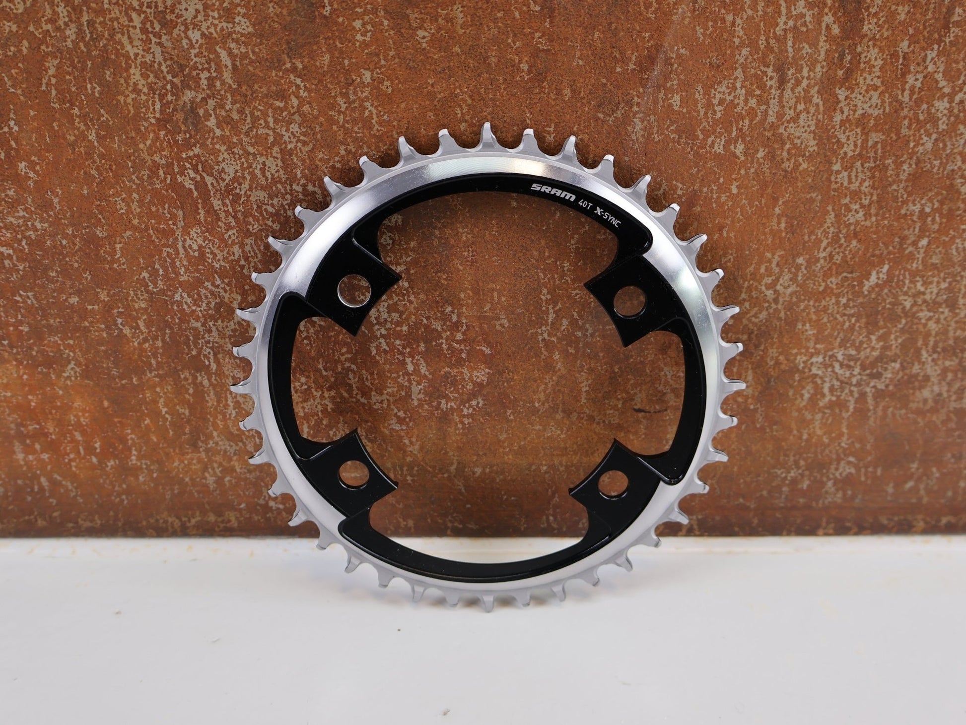 Kettenblatt von Sram, SRAM X - SYNC ROAD KETTENBLATT / 40 ZÄHNE / 107 MM BCD / 1X12 - FACH / BLAST BLACK vor USEDBIKES - OB.DE Hintergrund