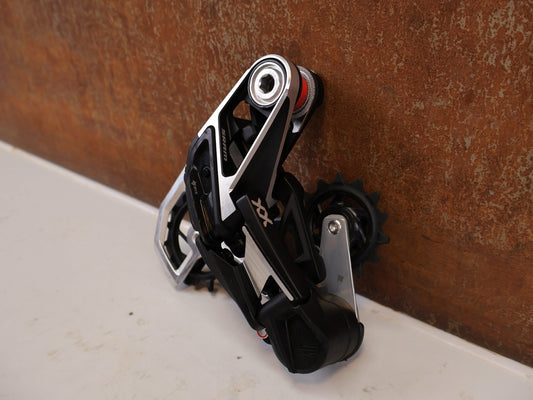 Schaltungsteile von Sram, SRAM XX Eagle AXS T-Type Schaltwerk 12-fach Silber 10-52T vor USEDBIKES-OB.DE Hintergrund