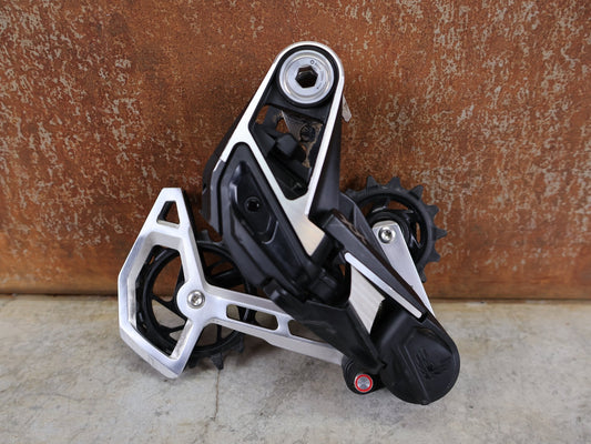 Schaltungsteile von Sram, SRAM XX EAGLE TRANSMISSION AXS T - TYPE SCHALTWERK / 12 - FACH – 10–52T – SILBER vor USEDBIKES - OB.DE Hintergrund