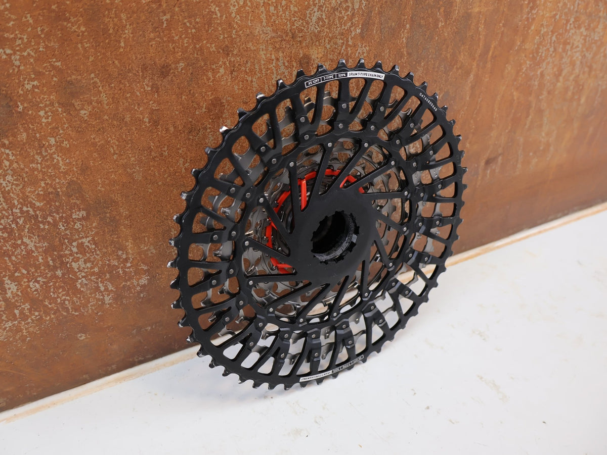 Kassette & Zahnkränze von Sram, SRAM XX Eagle XS-1297 T-Type Kassette 12-fach 10-52T Silber vor USEDBIKES-OB.DE Hintergrund