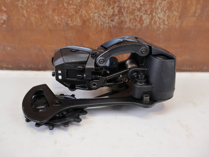 Schaltungsteile von Sram, SRAM XX1 Eagle AXS 12-fach Schaltwerk 52Z Carbon Titan vor USEDBIKES-OB.DE Hintergrund