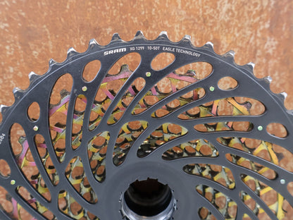 Kassette & Zahnkränze von Sram, SRAM XX1 Eagle XG-1299 Kassette 10-50T Rainbow XD 358g vor USEDBIKES-OB.DE Hintergrund