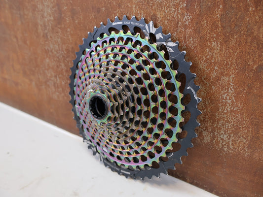 Kassette & Zahnkränze von Sram, SRAM XX1 Eagle XG-1299 Kassette 10-50T Rainbow XD 358g vor USEDBIKES-OB.DE Hintergrund