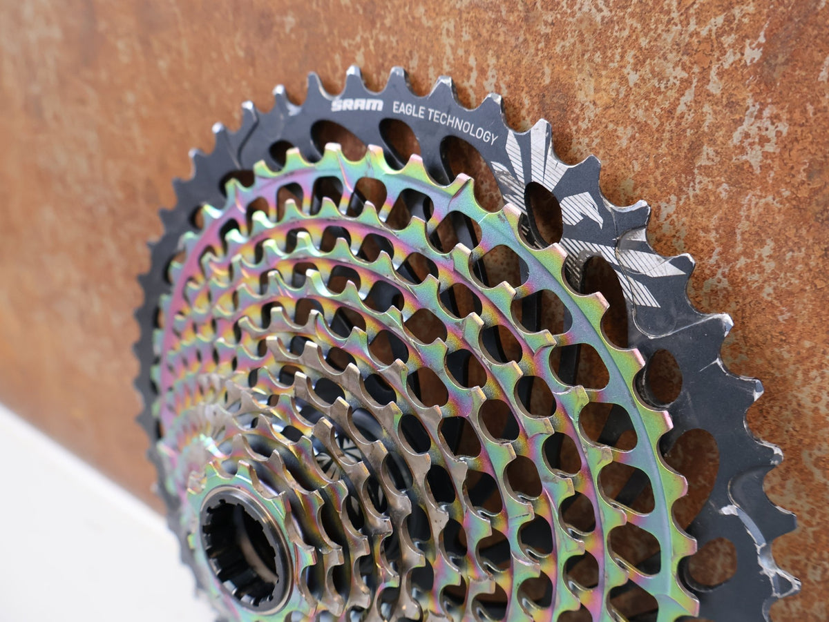 Kassette & Zahnkränze von Sram, SRAM XX1 Eagle XG-1299 Kassette 10-50T Rainbow XD 358g vor USEDBIKES-OB.DE Hintergrund