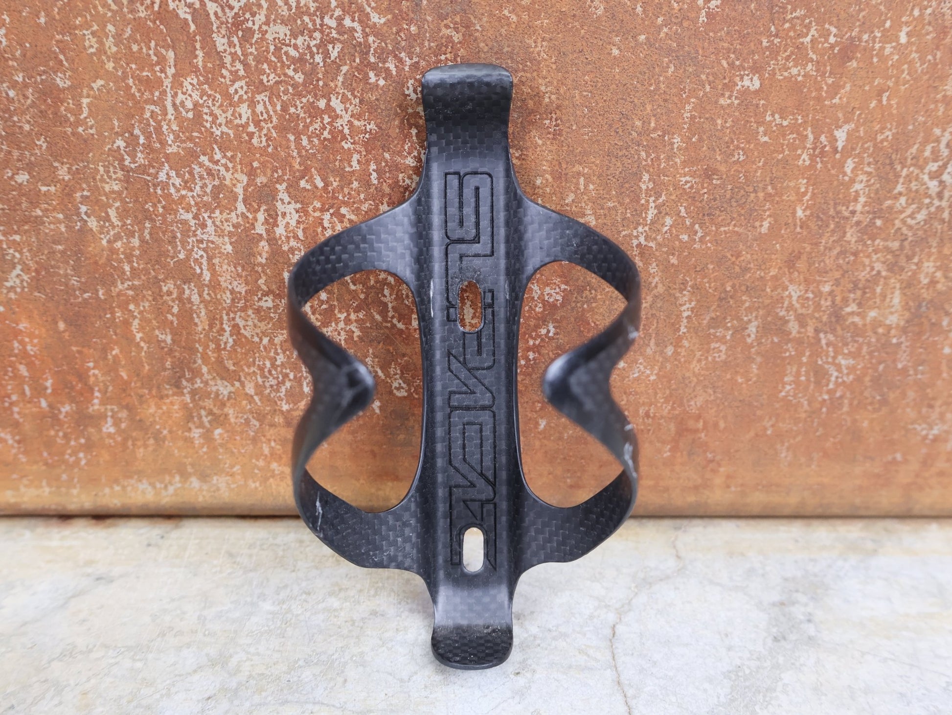 Trinkflaschen und Halter von Supacaz, SUPACAZ BLACK CARBON FLY FLASCHENHALTER / CARBON / 21 G vor USEDBIKES - OB.DE Hintergrund