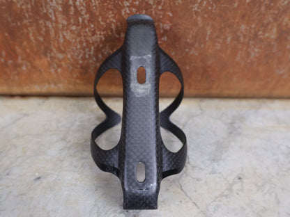 Trinkflaschen und Halter von Supacaz, SUPACAZ BLACK CARBON FLY FLASCHENHALTER / CARBON / 21 G vor USEDBIKES - OB.DE Hintergrund