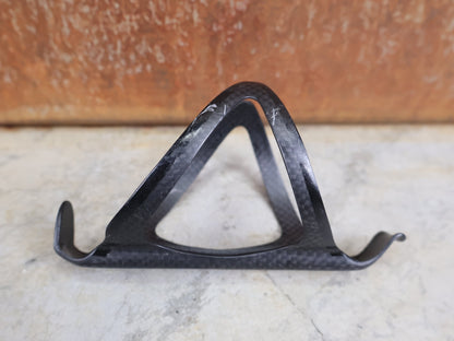 Trinkflaschen und Halter von Supacaz, SUPACAZ BLACK CARBON FLY FLASCHENHALTER / CARBON / 21 G vor USEDBIKES - OB.DE Hintergrund