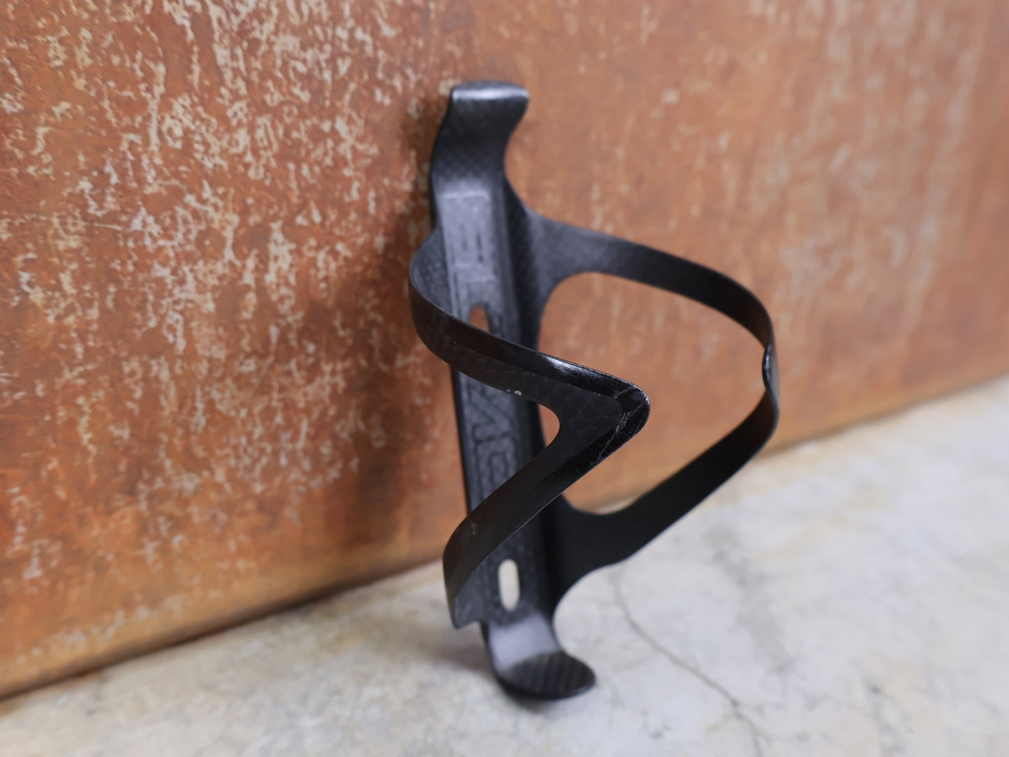 Trinkflaschen und Halter von Supacaz, SUPACAZ BLACK CARBON FLY FLASCHENHALTER / CARBON / 21 G vor USEDBIKES - OB.DE Hintergrund