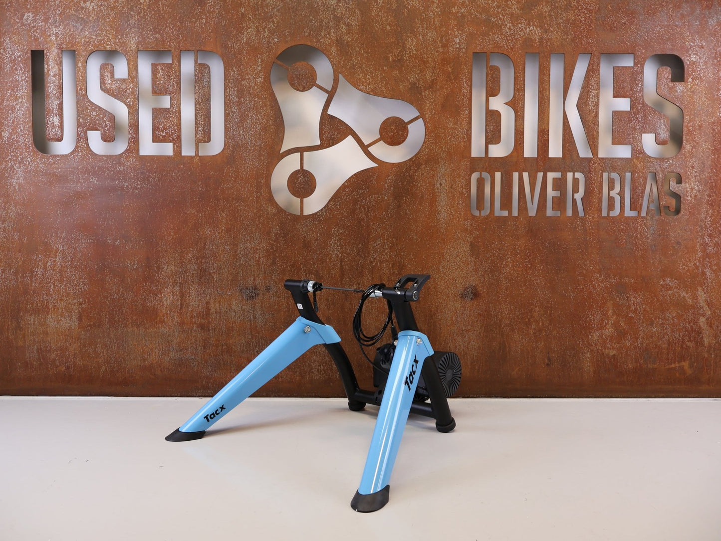 Rollentrainer von Tacx, TACX BOOST ROLLENTRAINER HEIMTRAINER INKL. VORDERRADSTÜTZE vor USEDBIKES-OB.DE Hintergrund
