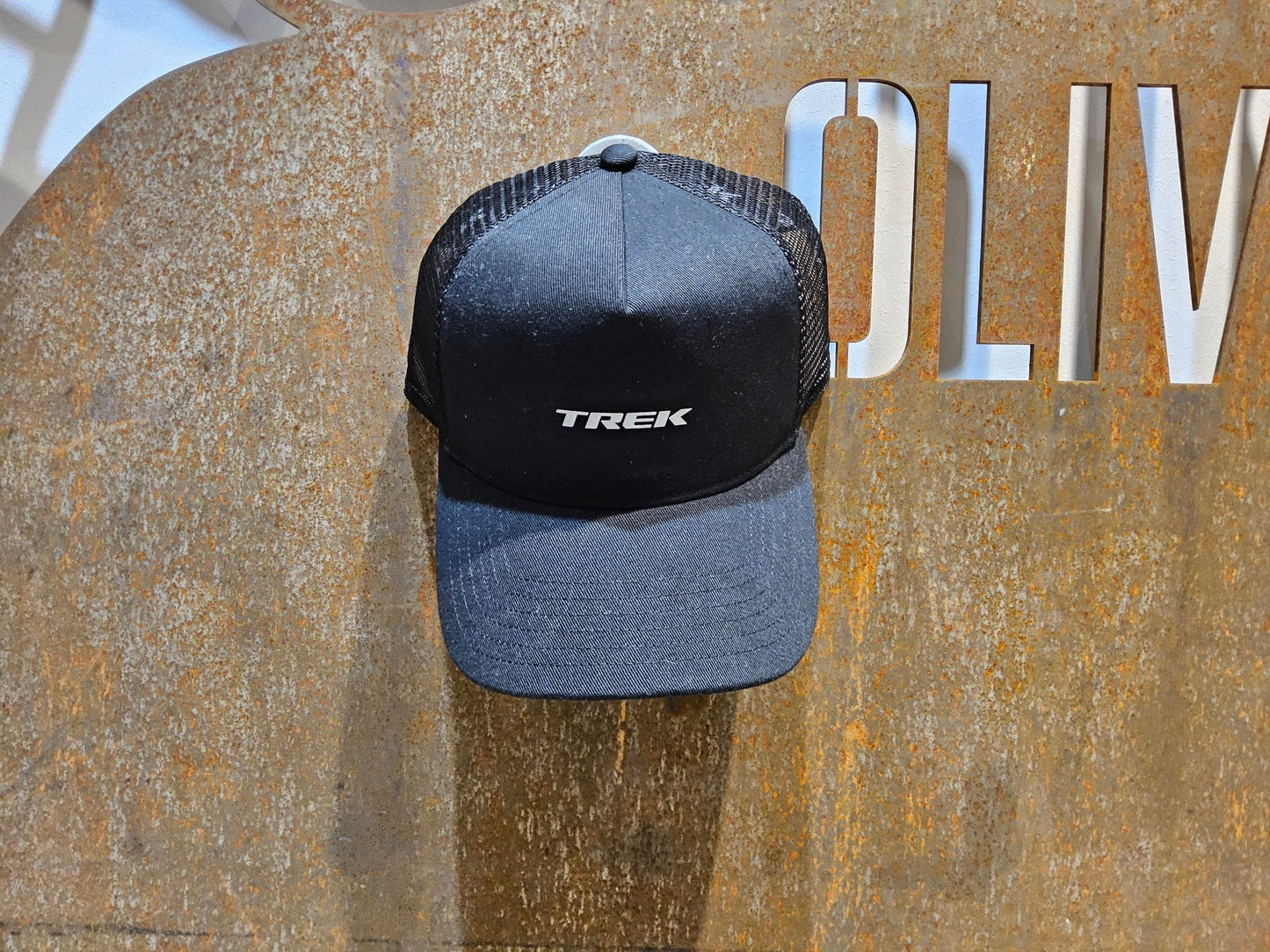 Freizeitbekleidung von Trek, TREK BLACK LOGO HAT / SNAPBACK TRUCKERCAP vor USEDBIKES - OB.DE Hintergrund