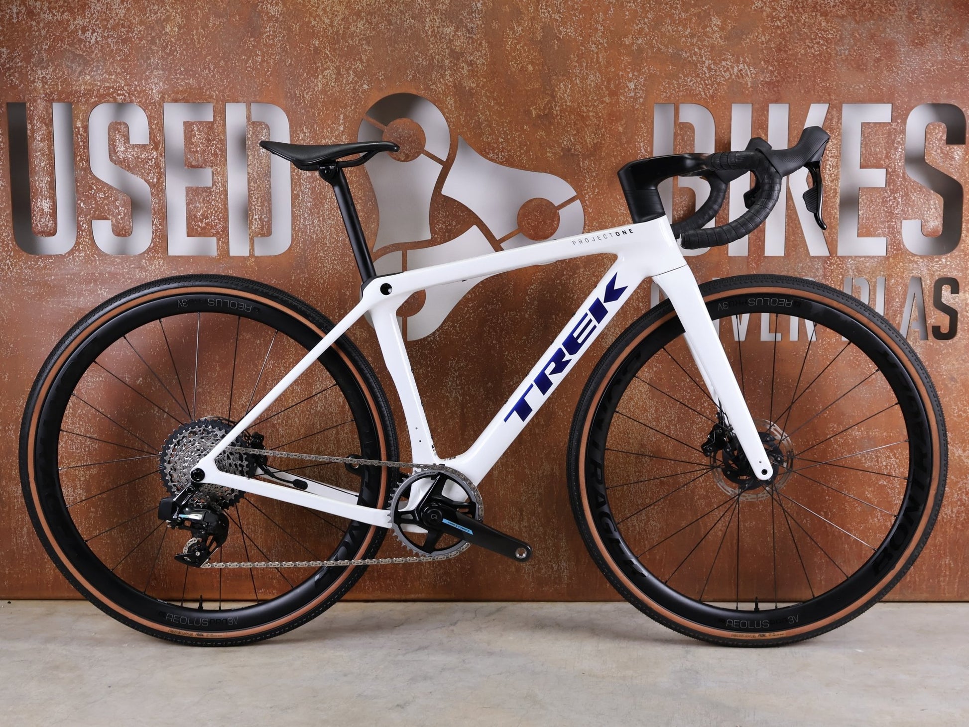 Gravel/Cyclocross von Trek, TREK CHECKMATE SLR 7 AXS – PROJECT ONE CRYSTAL WHITE / CRYSTAL BLUE / S vor USEDBIKES - OB.DE Hintergrund