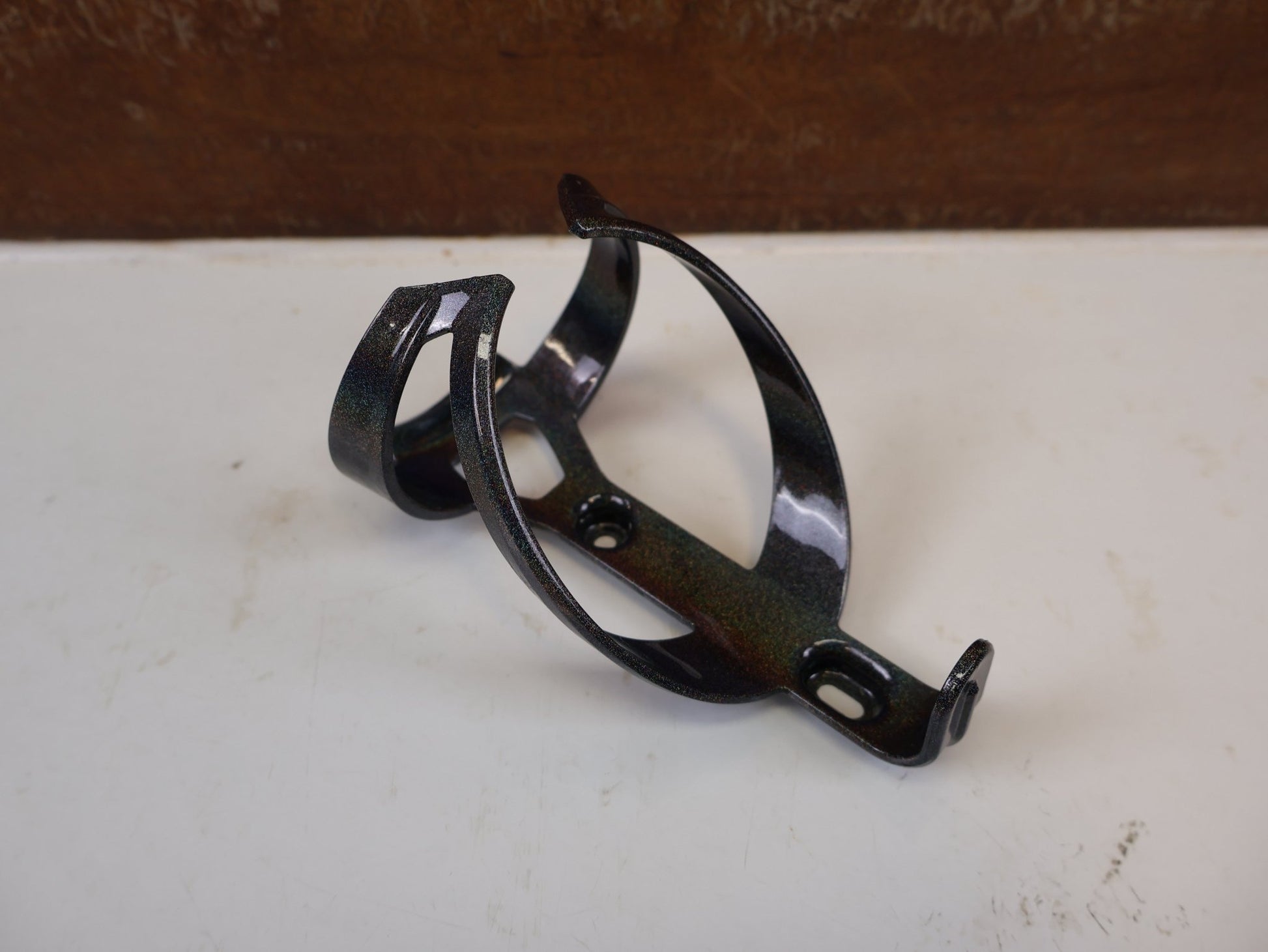 Trinkflaschen und Halter von Trek, TREK ELITE RECYCLED FLASCHENHALTER DARK PRISMATIC GOLD vor USEDBIKES-OB.DE Hintergrund