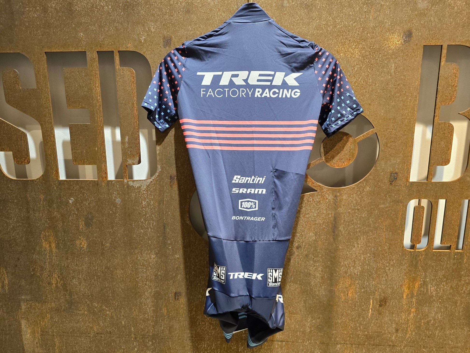 Damenbekleidung - TFR von Santini, TREK FACTORY RACING CX / CX SUIT SHORTSLEEVE SUPERLIGHT W. PKT / EINTEILER / DAMEN in variant_title vor USEDBIKES - OB.DE Hintergrund
