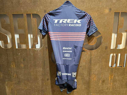 Damenbekleidung - TFR von Santini, TREK FACTORY RACING CX / CX SUIT SHORTSLEEVE SUPERLIGHT W. PKT / EINTEILER / DAMEN in variant_title vor USEDBIKES - OB.DE Hintergrund