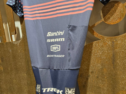 Damenbekleidung - TFR von Santini, TREK FACTORY RACING CX / CX SUIT SHORTSLEEVE SUPERLIGHT W. PKT / EINTEILER / DAMEN in variant_title vor USEDBIKES - OB.DE Hintergrund