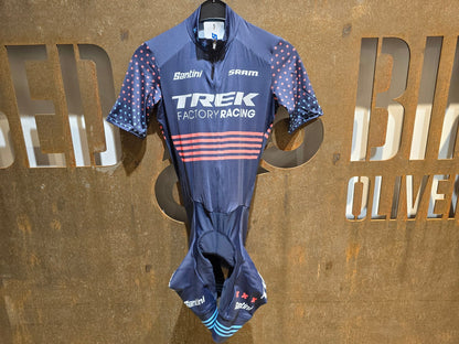 Damenbekleidung - TFR von Santini, TREK FACTORY RACING CX / CX SUIT SHORTSLEEVE SUPERLIGHT W. PKT / EINTEILER / DAMEN in variant_title vor USEDBIKES - OB.DE Hintergrund