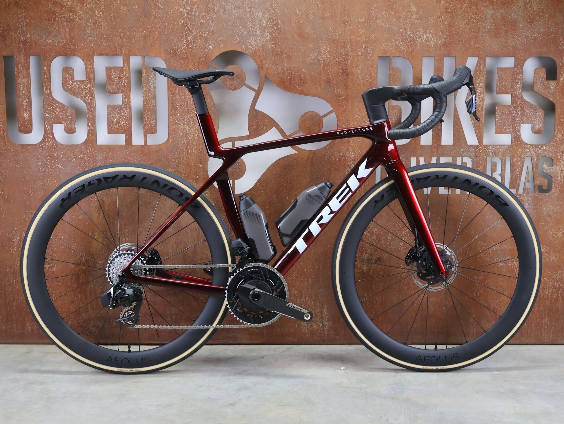 Rennrad von Trek, TREK MADONE SLR 7 AXS MY 2026 / CARBON RED SMOKE / M vor USEDBIKES - OB.DE Hintergrund