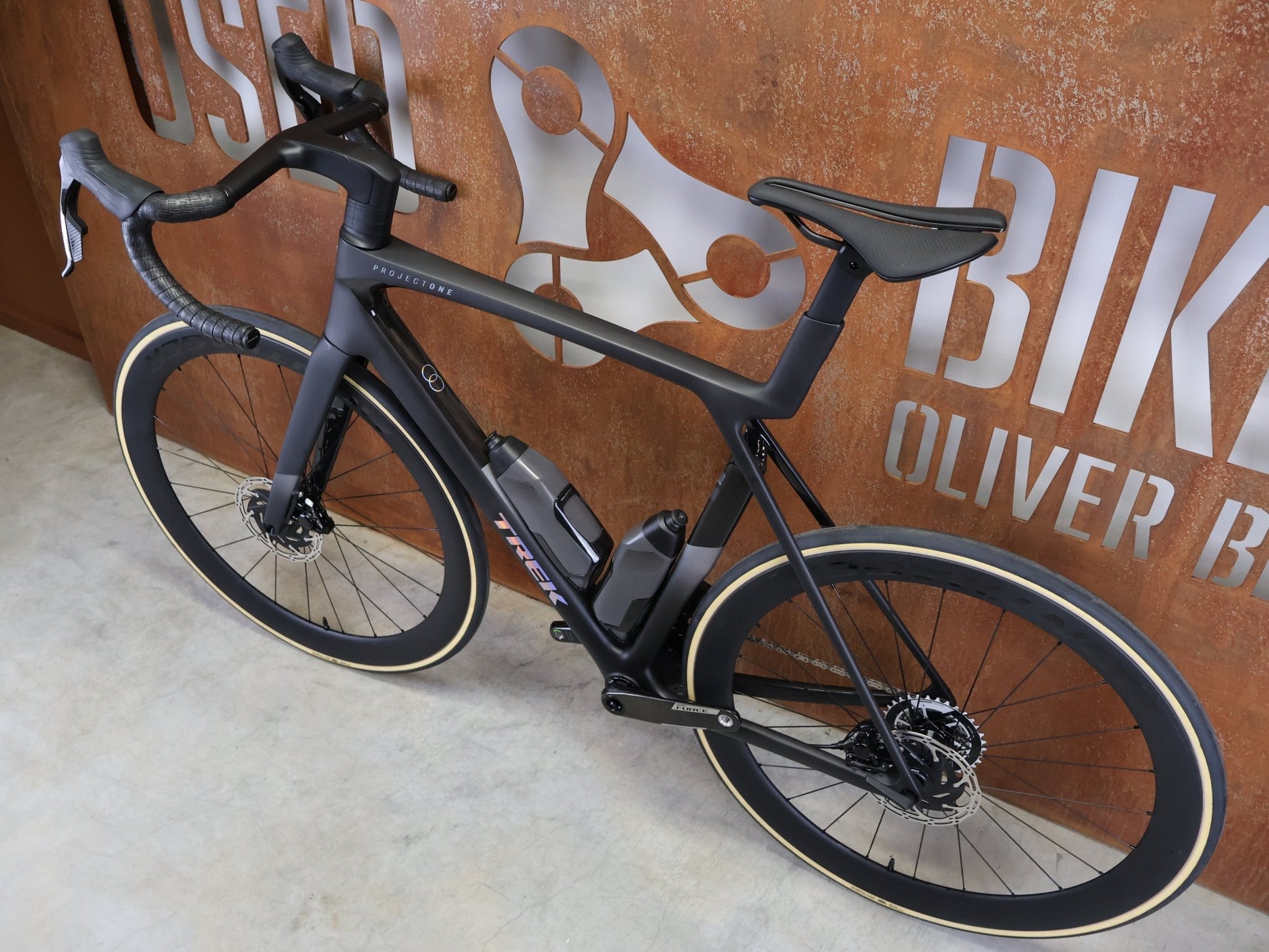 Rennrad von Trek, TREK MADONE SLR 7 AXS MY 2026 / MATTE CARBON SMOKE / L vor USEDBIKES - OB.DE Hintergrund