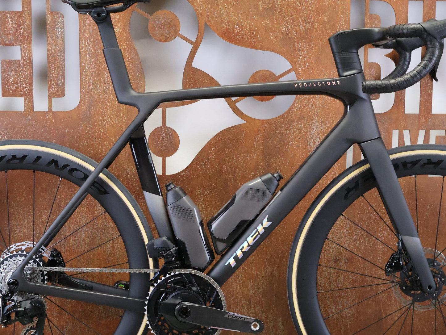 Rennrad von Trek, TREK MADONE SLR 7 AXS MY 2026 / MATTE CARBON SMOKE / L vor USEDBIKES - OB.DE Hintergrund